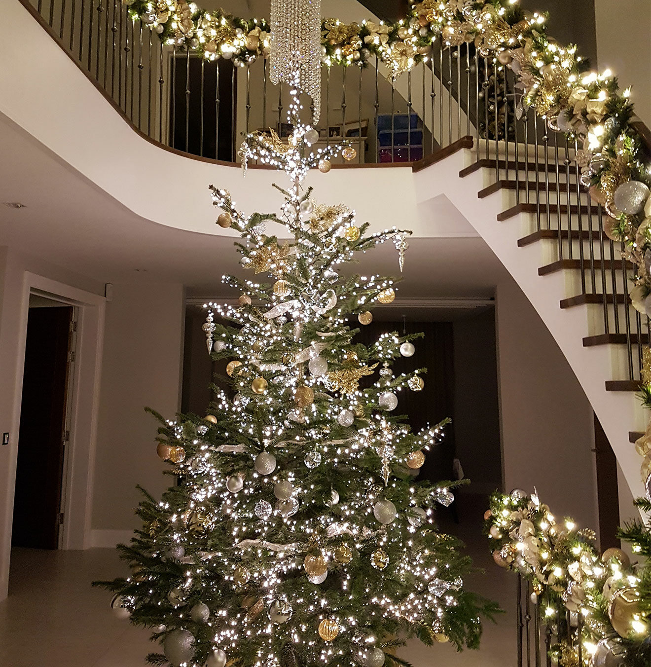 Silver and gold real Christmas tree set in a grand entrance to a residential home in Sevenoaks.