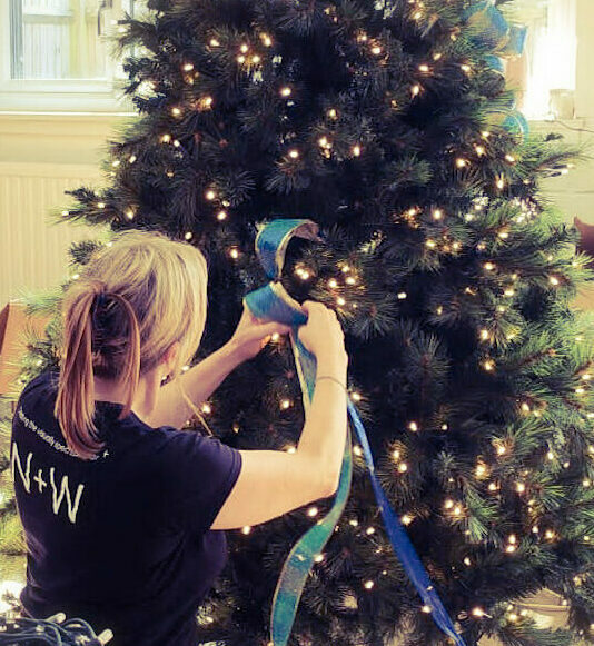 Noble+Whyte team working hard on a blue and silver themed Christmas tree, getting ready for installation.