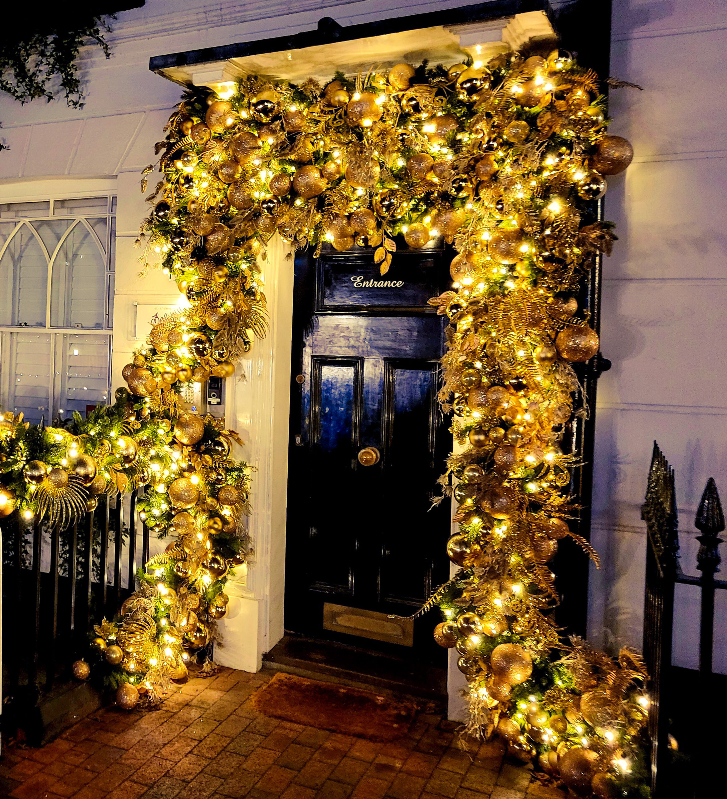 Gold bauble and warm white lights doorscape for a commercial client in Tunbridge Wells Kent.